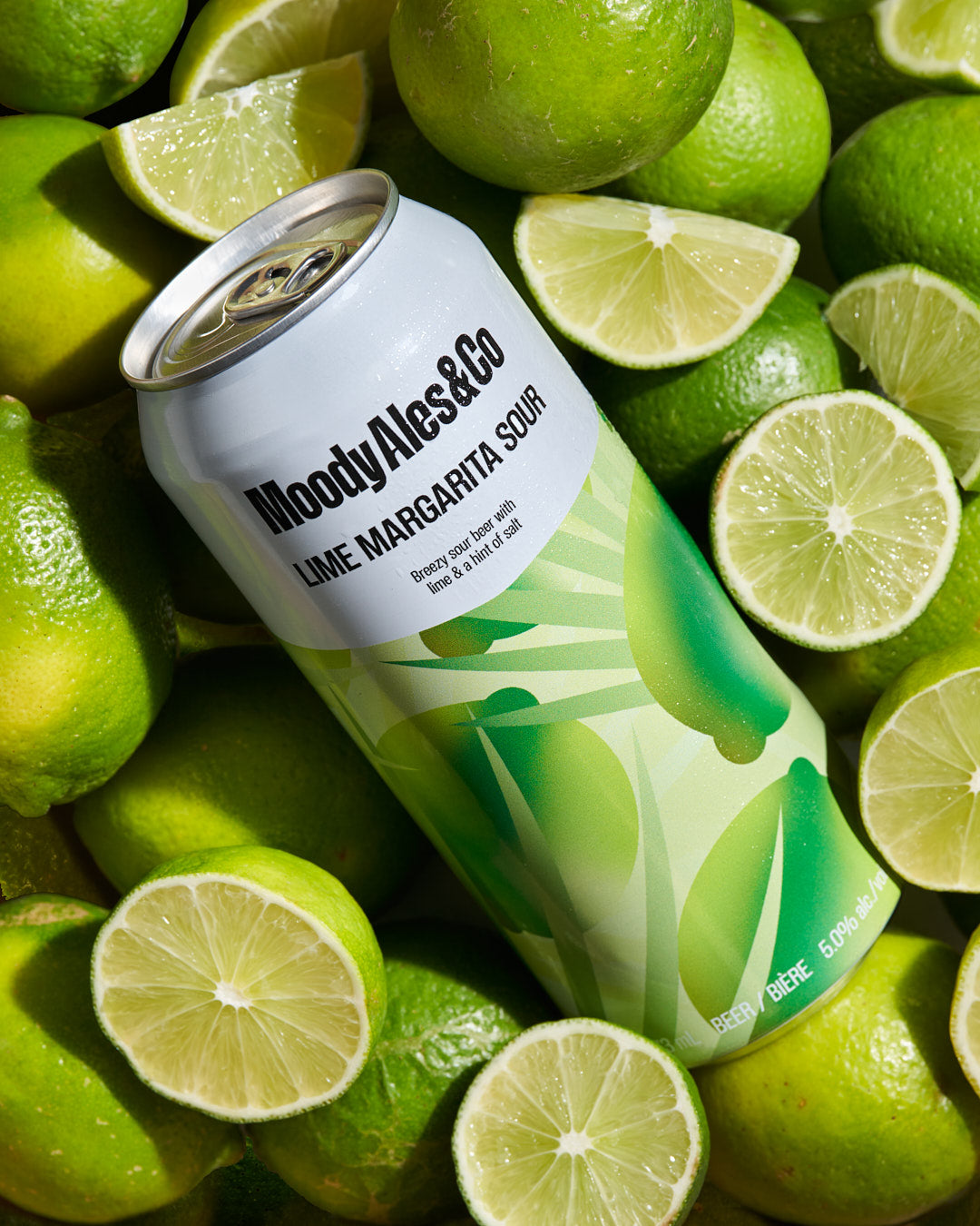 lime margarita sour can amongst limes
