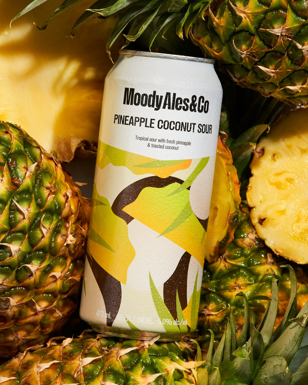 pineapple coconut sour can amongst pineapple